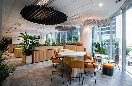 Modern office space with unique wood and metal furniture, plants, and lighting fixtures.