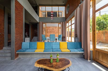 Spacious modern interior with colorful seating, wooden furniture, and large windows.