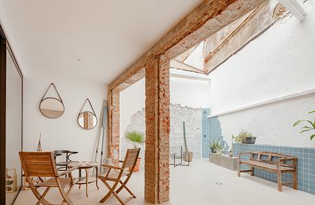 Minimalist interior with exposed brick walls, wooden furniture, and modern decor.