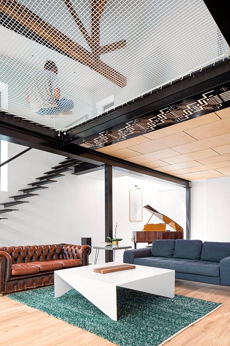 Sleek modern living room featuring a leather sofa, ornate ceiling, and geometric rug.