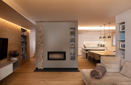 Sleek, modern interior with a fireplace feature wall, wood floors, and pendant lighting.