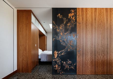 A modern, minimalist bedroom with a bold, abstract wall mural and wood paneling.