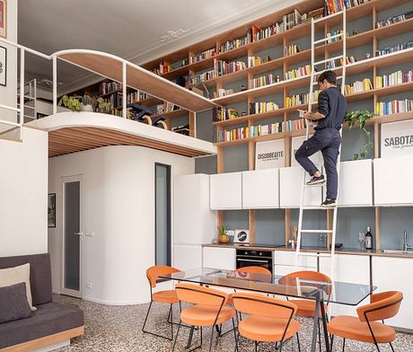 Expansive floor-to-ceiling bookshelves, recessed lighting, and an elevated study nook create a modern, cozy space.