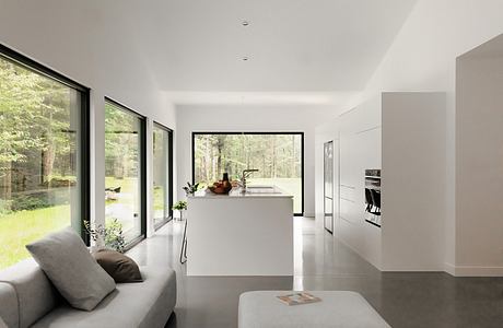 An open-concept modern kitchen with large windows overlooking a lush wooded area, featuring minimalist design and neutral tones.