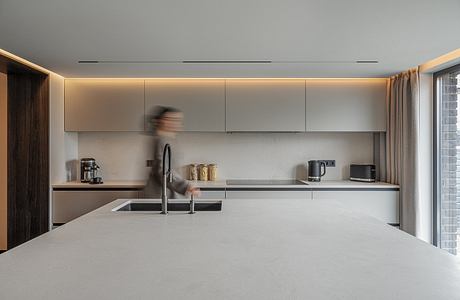 Modern kitchen with sleek cabinets, minimalist lighting, and a spacious countertop.