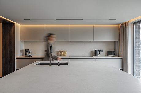 Modern kitchen with sleek cabinets, minimalist lighting, and a spacious countertop.