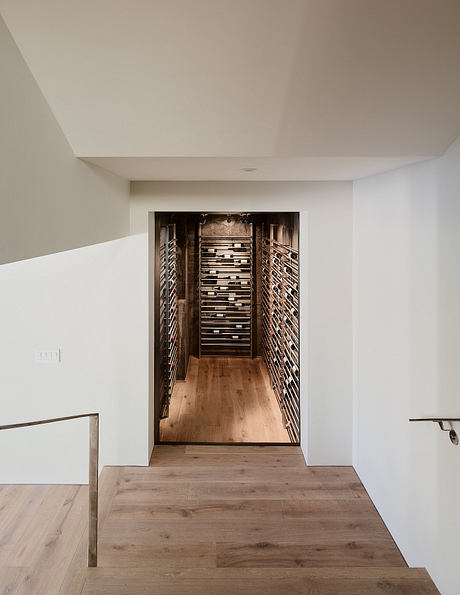 Expansive wine cellar with wooden shelves occupying a long, narrow space.