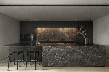 A sleek, modern kitchen with black marble countertops, minimalist cabinetry, and subtle lighting.