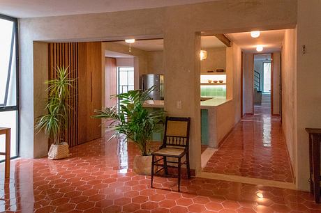 Warm-toned interior with hexagonal terracotta floors, potted plants, and wooden accents.