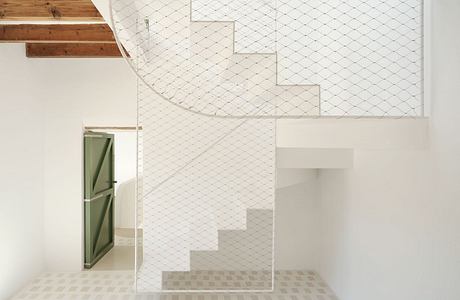 Minimalist architecture with geometric patterns, wooden details, and a white staircase.