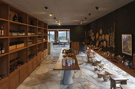 A cozy, rustic interior with wooden shelves, a stone floor, and a central dining table.