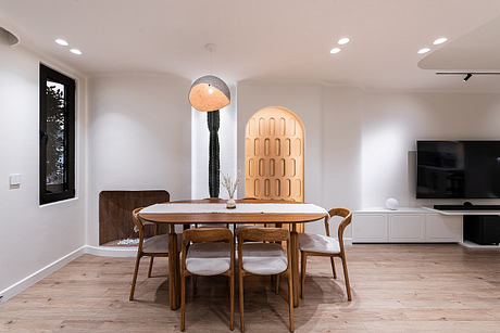 Spacious, modern dining area with wooden table and chairs, pendant lamps, and architectural details.