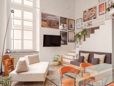Bright, modern living room with eclectic wall art and a mix of retro and contemporary furniture.
