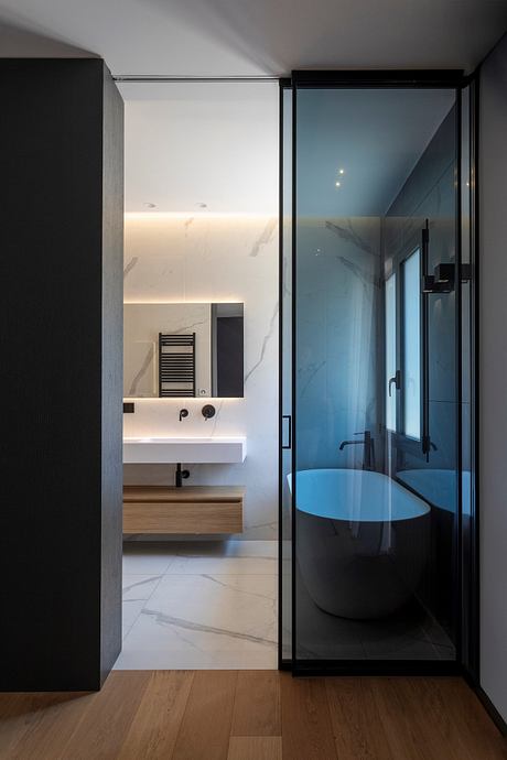 Sleek and modern bathroom design with black accents, glass partition, and stone vanity.
