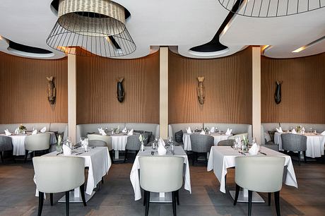 Elegant dining room with intricate lighting fixtures, textured walls, and modern furniture.