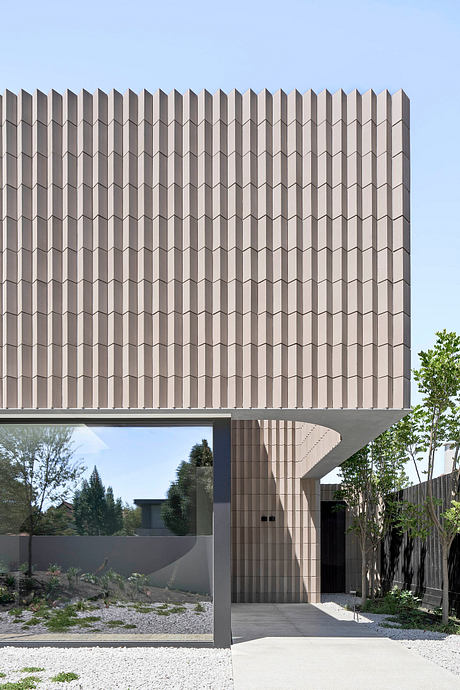 Modern geometric facade with repeating angled elements, creating a striking architectural design.