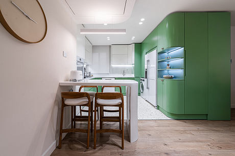 A modern kitchen with white and green color scheme, wooden accents, and open shelving.
