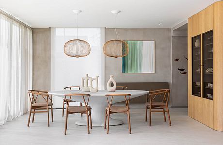 Elegant modern dining room with minimalist furnishings, pendant lamps, and artwork.