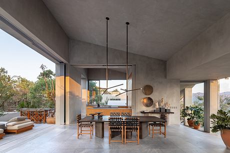 Minimalist concrete interior with bold pendant lights and rustic wood furniture.