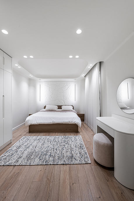 Modern bedroom with clean lines, recessed lighting, and textured accent wall.