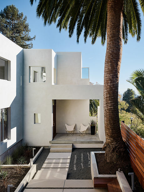 Minimalist architectural design featuring geometric forms, clean lines, and lush landscaping.