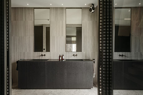 Sleek, modern bathroom with black cabinetry, tiled walls, and recessed lighting.