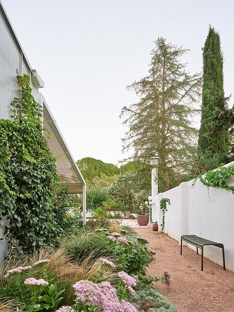 Lush landscape with architectural details, inviting outdoor seating, and diverse plantings.