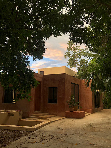 A contemporary, earth-toned villa with clean lines, surrounded by lush greenery.