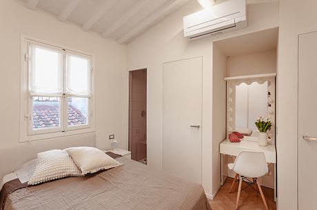 Bright, airy bedroom with wooden ceiling, large windows, and minimalist furnishings.