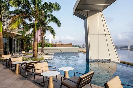 Sleek, modern outdoor lounge area with infinity pool and cityscape view.
