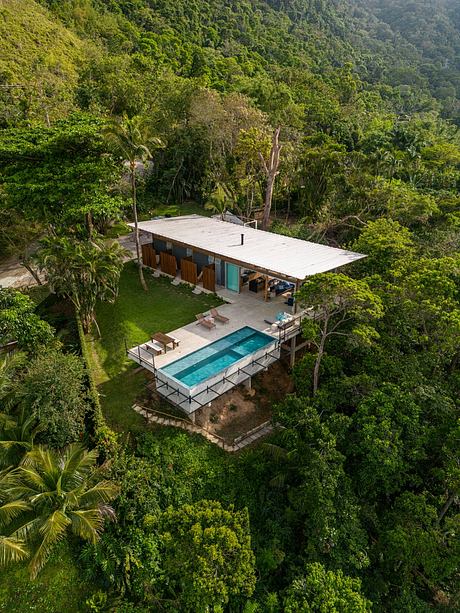 Stunning modern home nestled in verdant jungle canopy with infinity pool.