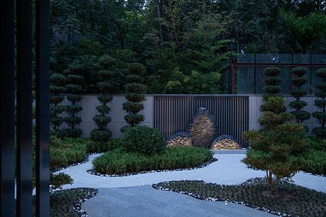 Serene Japanese-inspired garden with sculptural rock formations, gravel paths, and pruned shrubs.