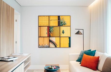 Vibrant wall art frames accent an airy, modern living space with warm furnishings.