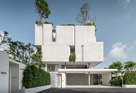 Modern, geometric building with potted plants and trees on the facade, creating a unique, minimalist architectural design.