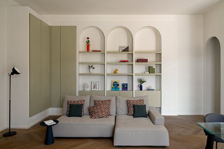 Cozy living room with modern built-in shelving, comfortable gray sofa, and wooden flooring.