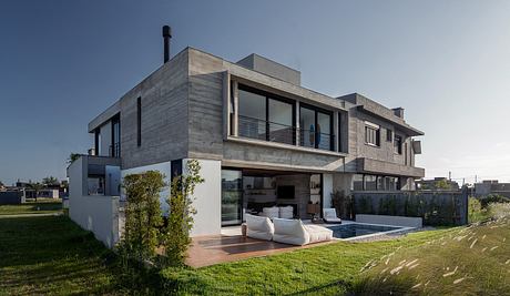 Striking modern architectural design with expansive glass windows and an outdoor living area.