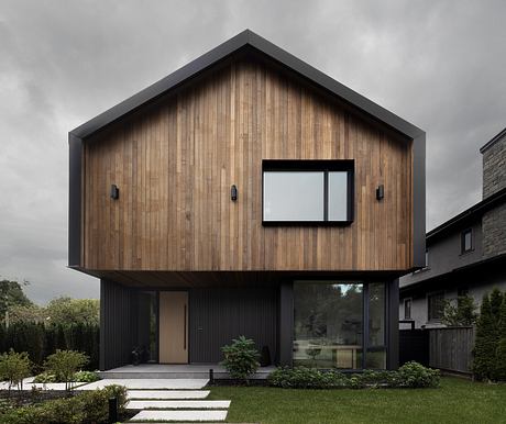 Modern wooden house with black trim, large windows, and a sleek, minimalist design.