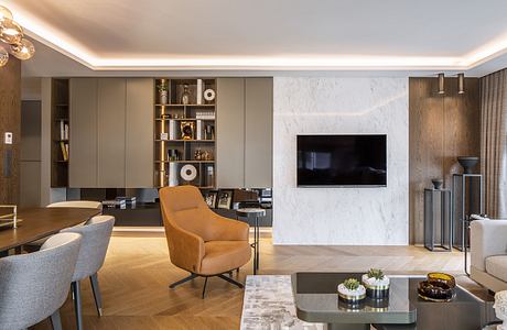 Elegant living room with marble accent wall, built-in shelving, and comfortable seating.