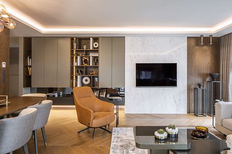 Elegant living room with marble accent wall, built-in shelving, and comfortable seating.