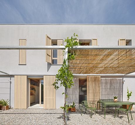 Contemporary exterior with wooden screens, potted plants, and minimal furniture.