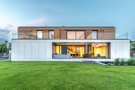 A modern two-story home with a wooden exterior, large windows, and an open floor plan.