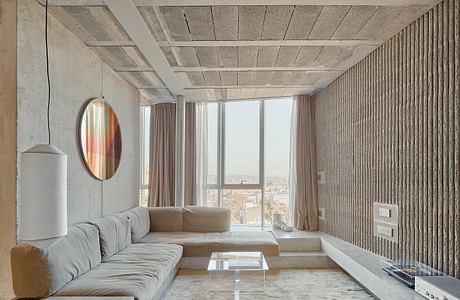 Expansive concrete-clad interior with panoramic city views, modern furnishings, and minimalist aesthetic.