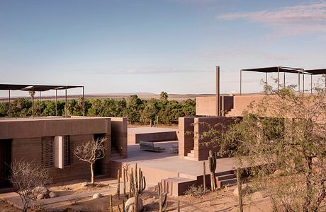 Modernist desert architecture with cantilevered roofs, cacti, and distant views.