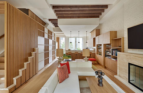 Wooden beams, built-in shelves, and a cozy seating area in this modern, open-concept space.