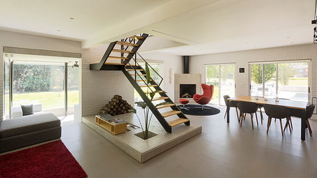 Spacious, modern interior with a striking steel staircase and cozy living area.