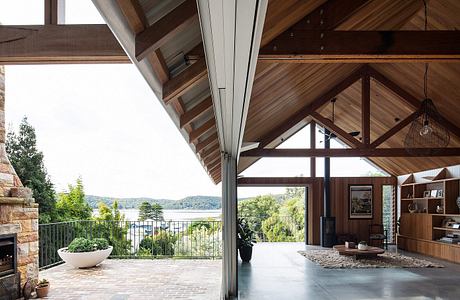 Stunning wood-beamed ceiling frames panoramic lake view through sliding glass doors.