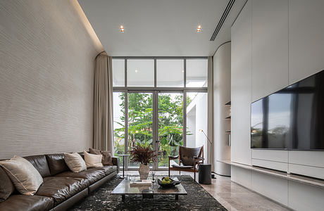 Spacious living room with large windows, minimalist furniture, and modern decor.