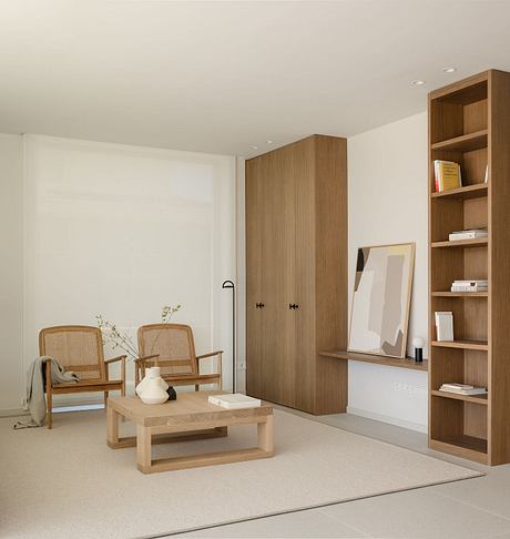 Stylish living room with minimal wood furniture, built-in shelves, and neutral color palette.