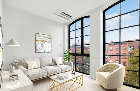 Bright, modern living room with large windows, plush sofa, and minimalist decor.