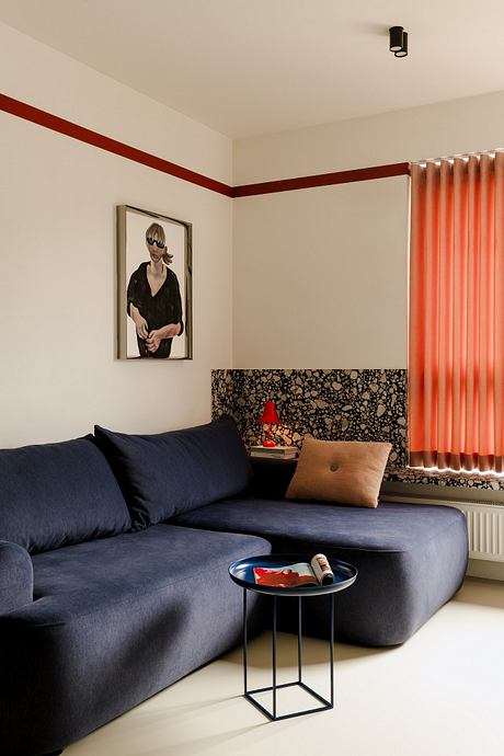 Minimalist living room with a modern sofa, patterned accent wall, and a side table.